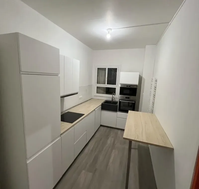 Cuisine équipée neuve : meubles blancs, plan de travail bois, plaque induction et four encastré