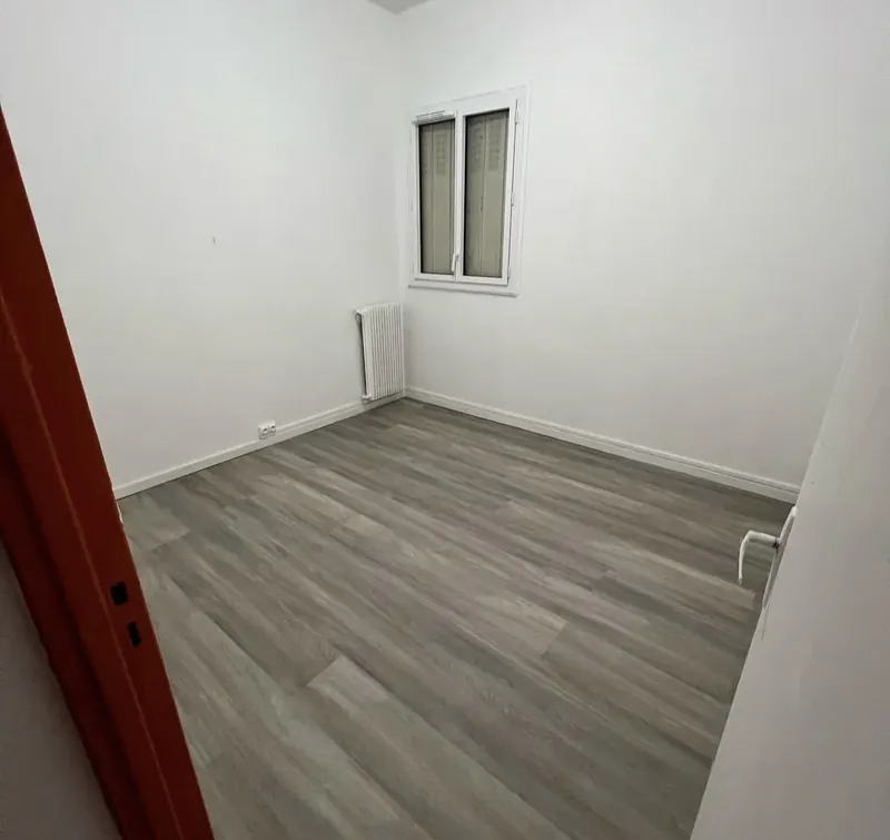 La même pièce repeinte en blanc, fenêtre neuve et sol PVC gris