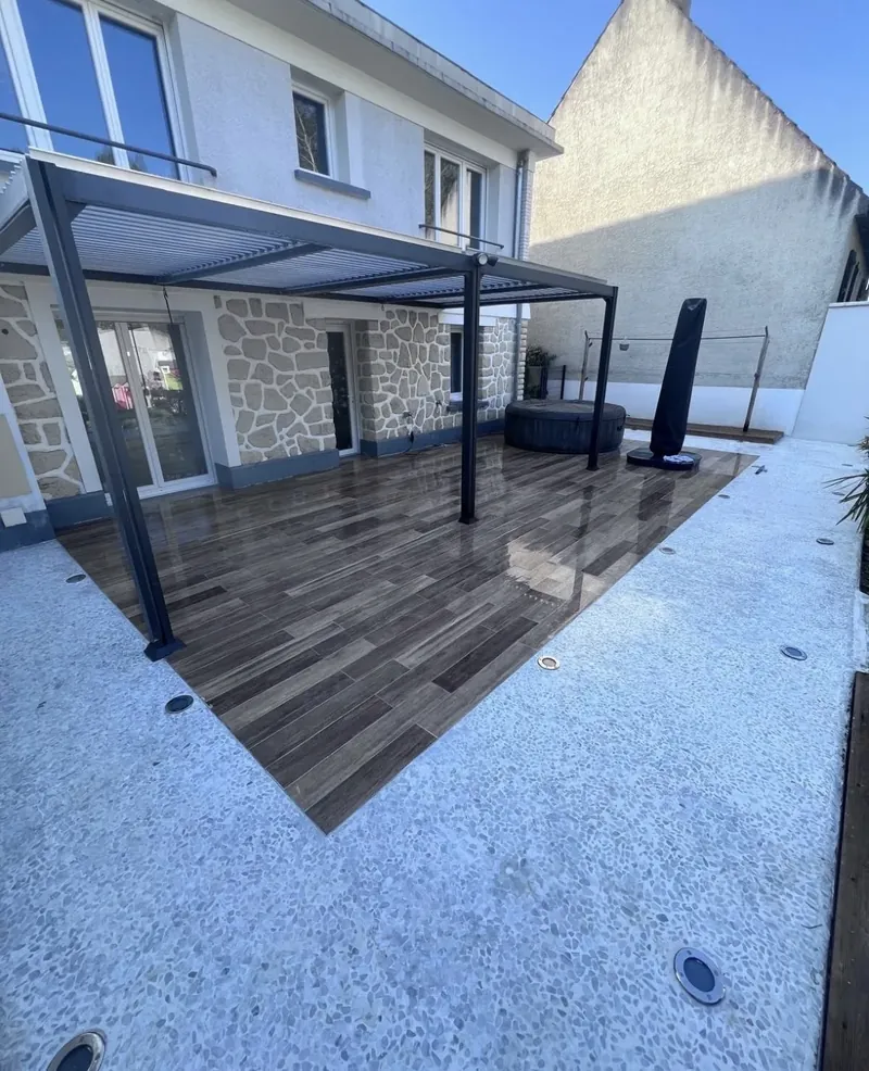 Dalle béton coulée, carrelage extérieur posé sous la pergola bioclimatique, entourage en béton désactivé blanc et spots encastrés au sol